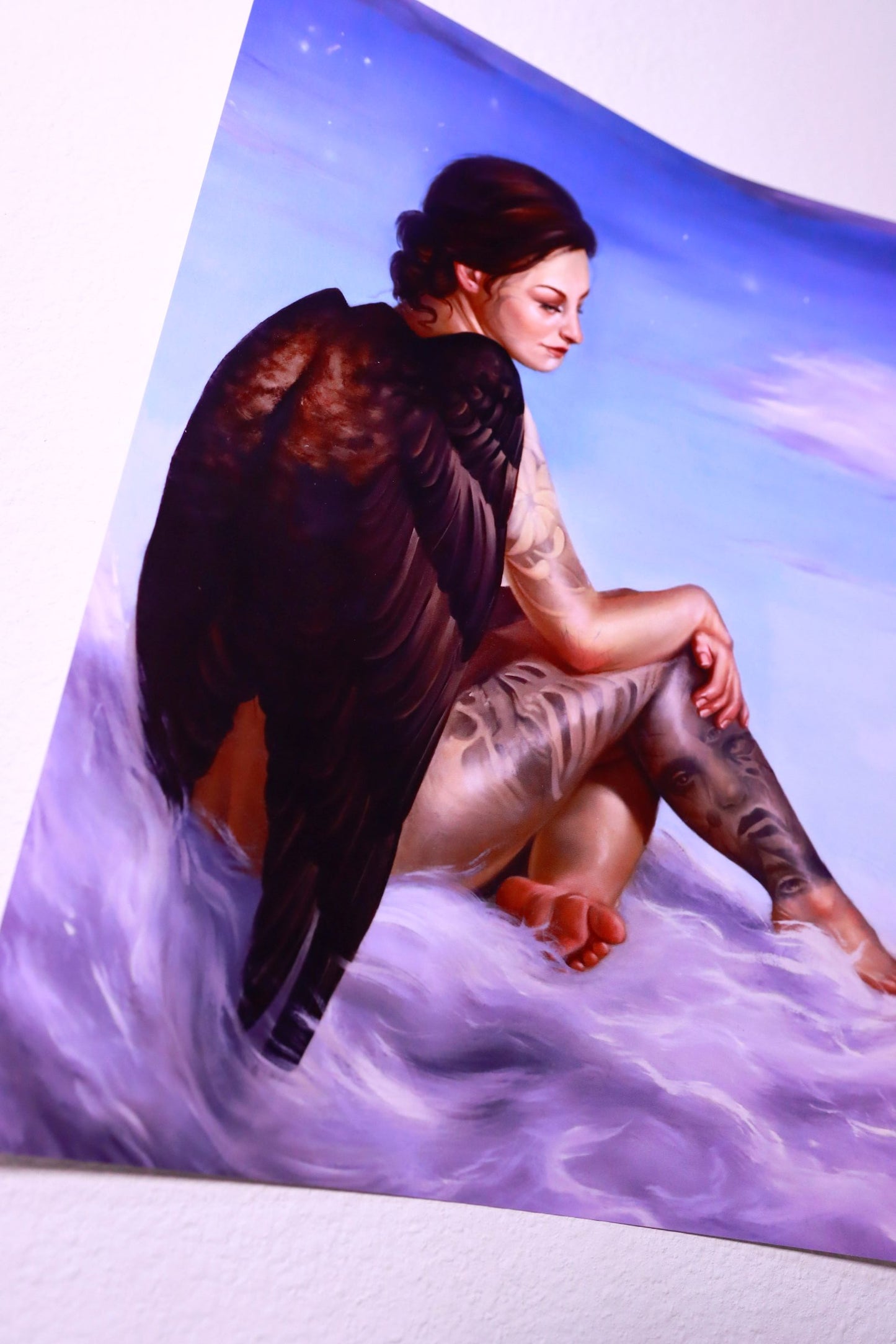 Person with tattoos lying on a purple and blue gradient surface