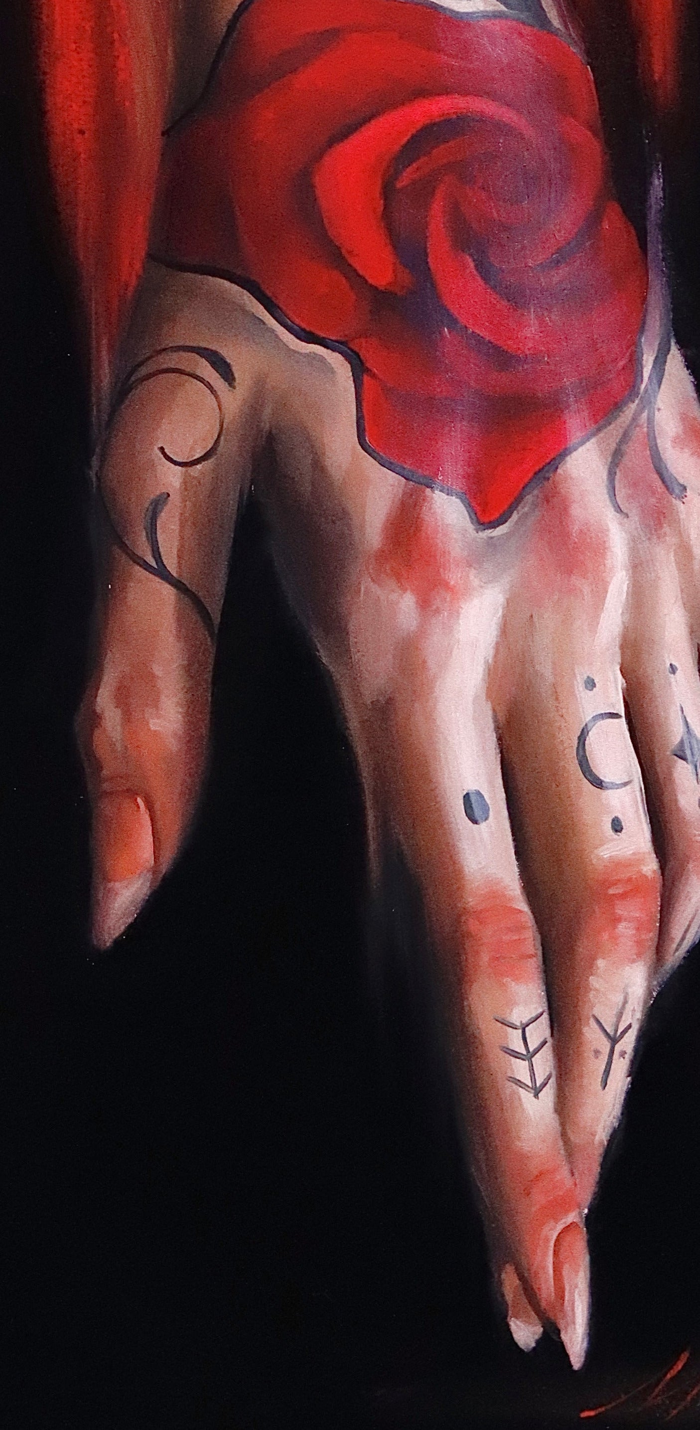 Tattooed arm with a stylized woman's face and red rose against a red and black background